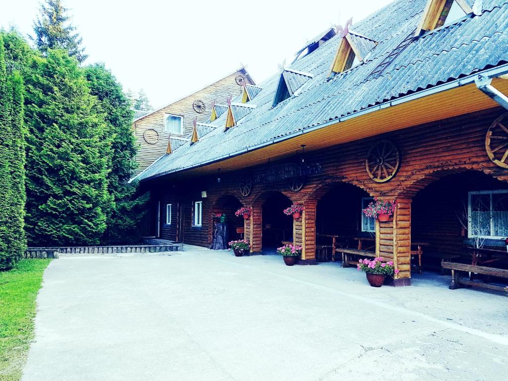 ein großes Backsteingebäude mit einer Veranda und einer Terrasse in der Unterkunft Kryzbarkas in Degučiai