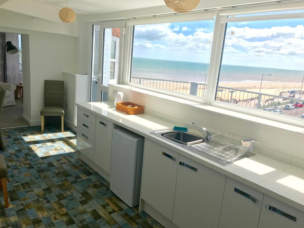 a kitchen with a view of the beach from a window at Apartments @52 in Bridlington