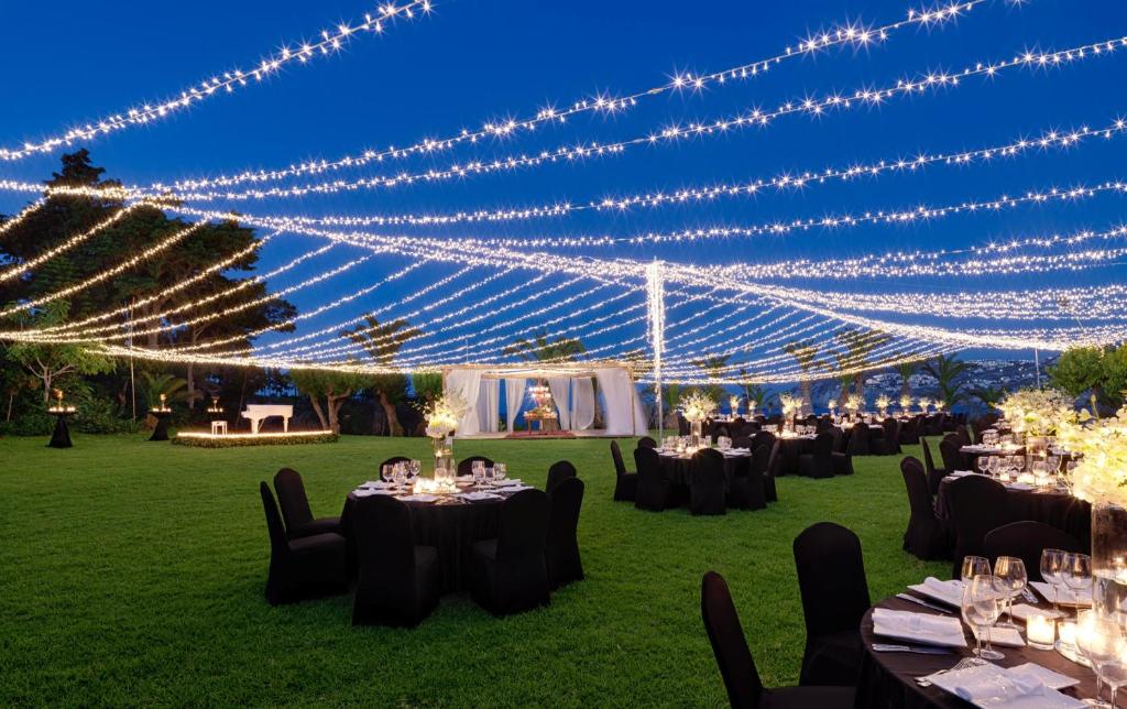 a group of tables in a field with lights at Out Of The Blue Resort & Spa in Agia Pelagia