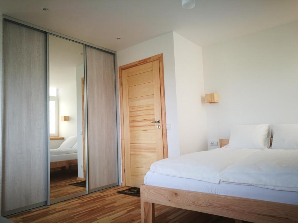 um quarto com uma cama e uma porta de vidro deslizante em Klevas em Karklė