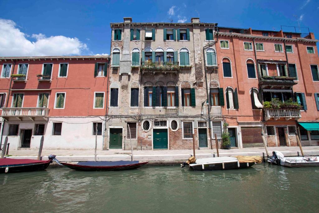 a group of boats in the water in front of buildings at DI.GIANFRANCO PIANO NOBILE in Venice