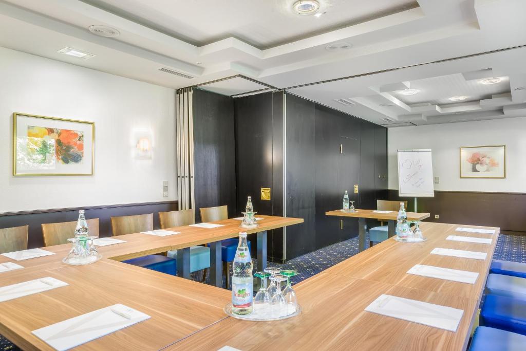 a conference room with wooden tables and chairs at Hotel Rega Stuttgart in Stuttgart