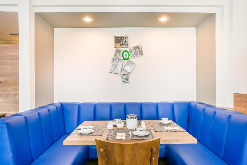 a blue booth in a restaurant with a table at Hotel Rega Stuttgart in Stuttgart