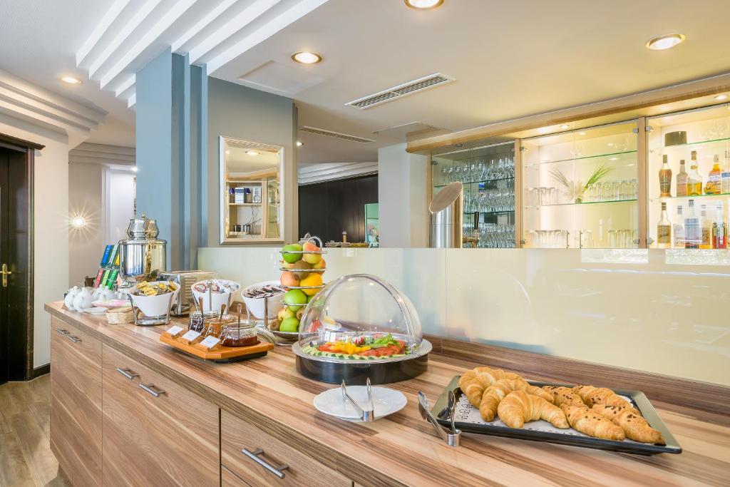 a buffet with bread and food on a table at Hotel Rega Stuttgart in Stuttgart
