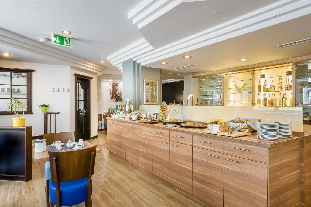 a large kitchen with wooden cabinets and a counter at Hotel Rega Stuttgart in Stuttgart