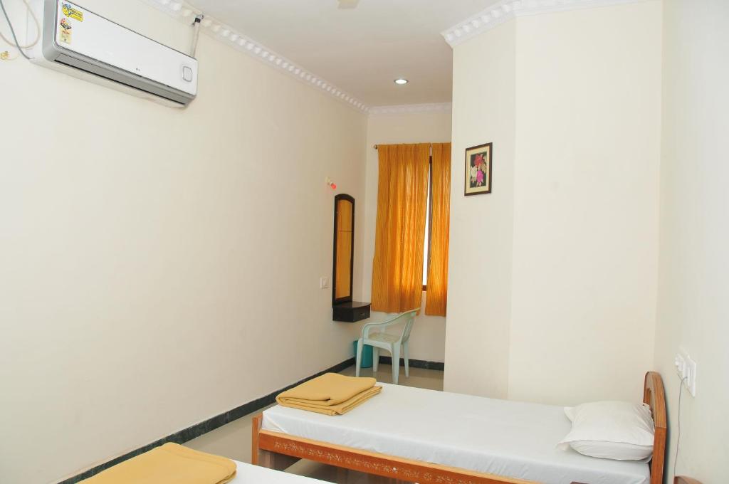 Postel nebo postele na pokoji v ubytování Hotel Nachiappa Palace
