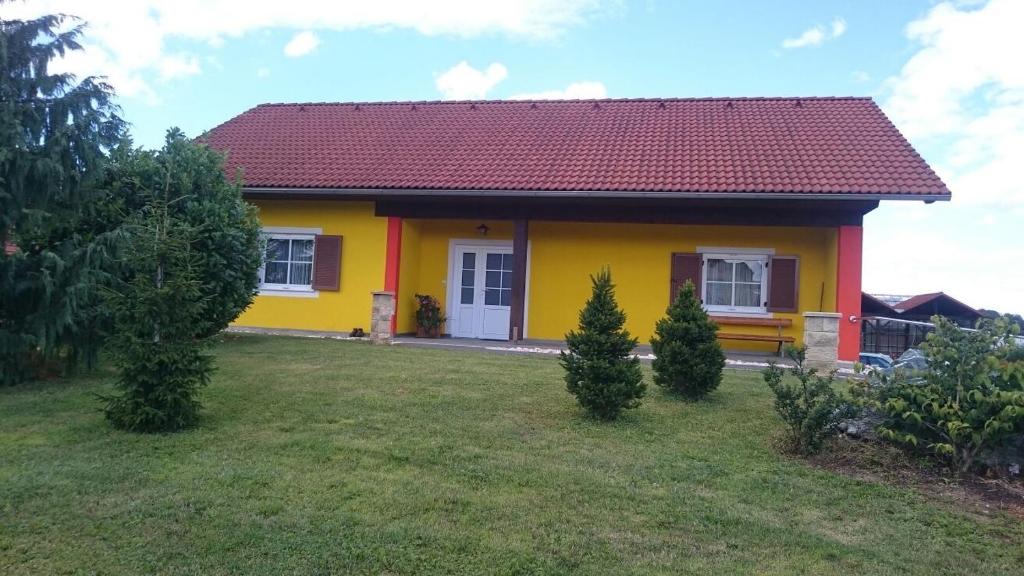 une maison jaune avec un toit rouge dans l'établissement Gartler's Ferienhaus, à Weitersfeld an der Mur