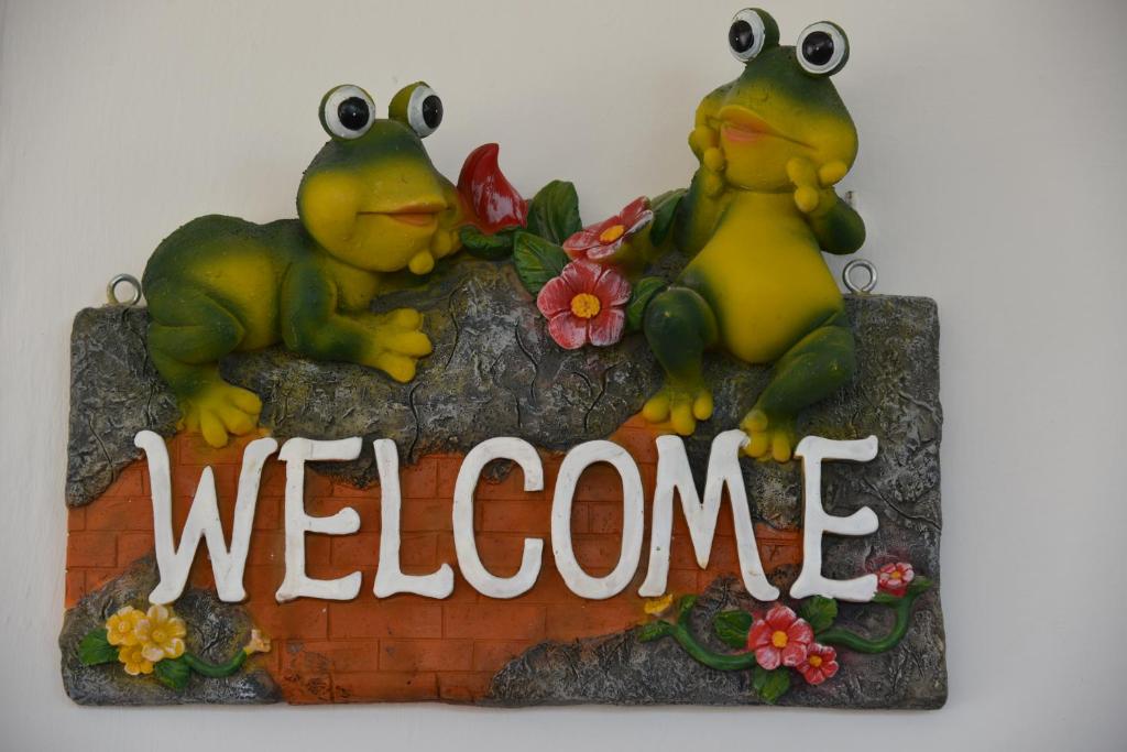 two frogs sitting on top of a welcome sign at Canto delle Rane in Vieste