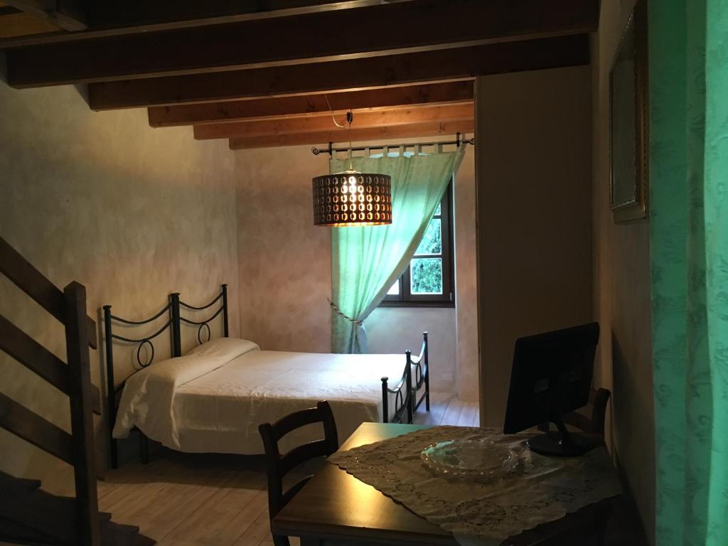 a bedroom with a bed and a table and a window at La Columbera in Trento