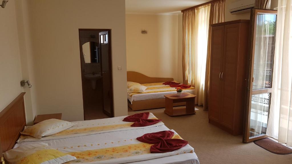 a hotel room with two beds and a mirror at Guest House Markovi Aheloy in Aheloy