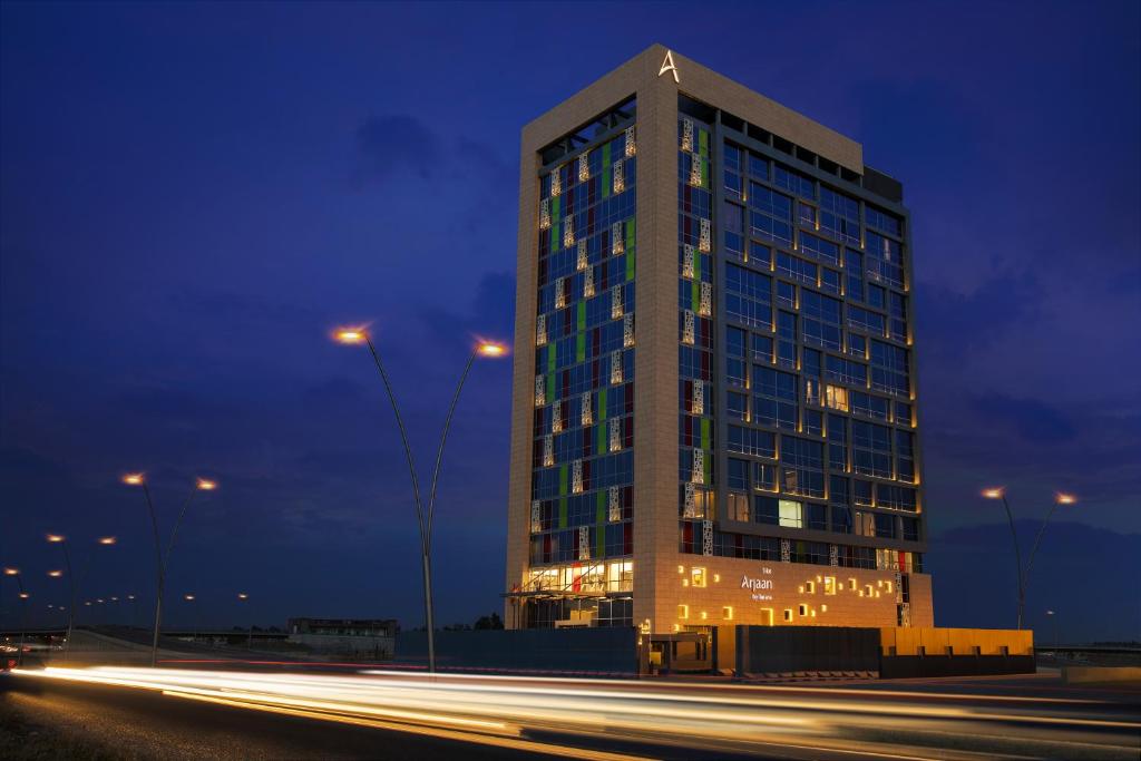 un grand bâtiment de nuit avec la circulation devant lui dans l'établissement Erbil Arjaan by Rotana, à Erbil