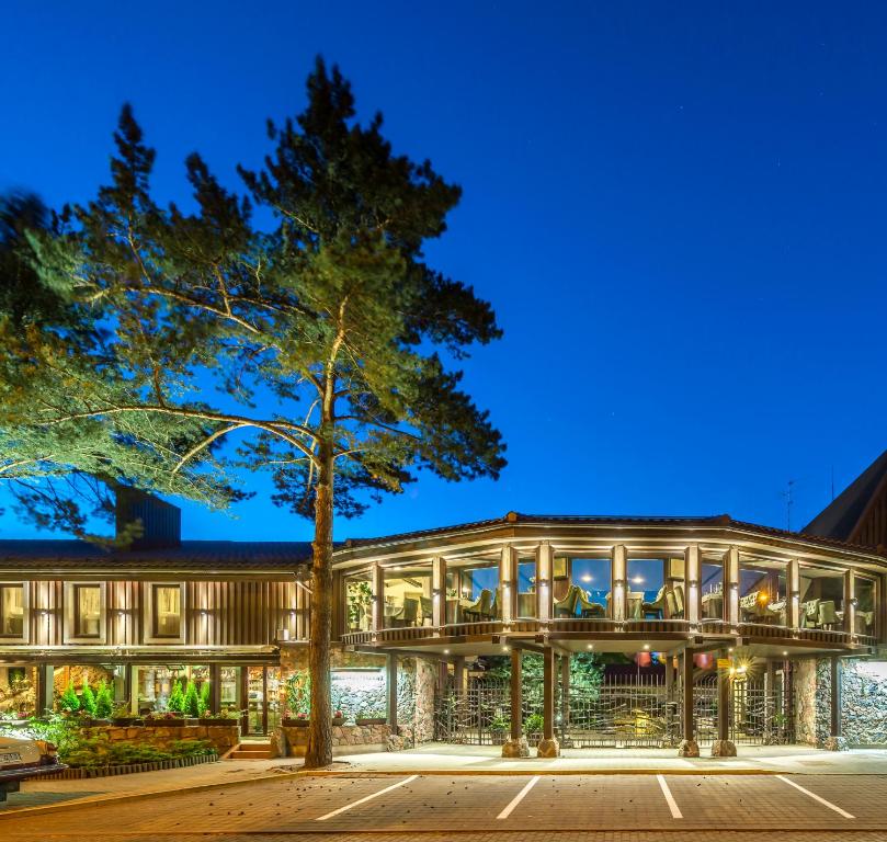 an exterior view of a building at night at Hotel Pušų paunksnėje in Palanga