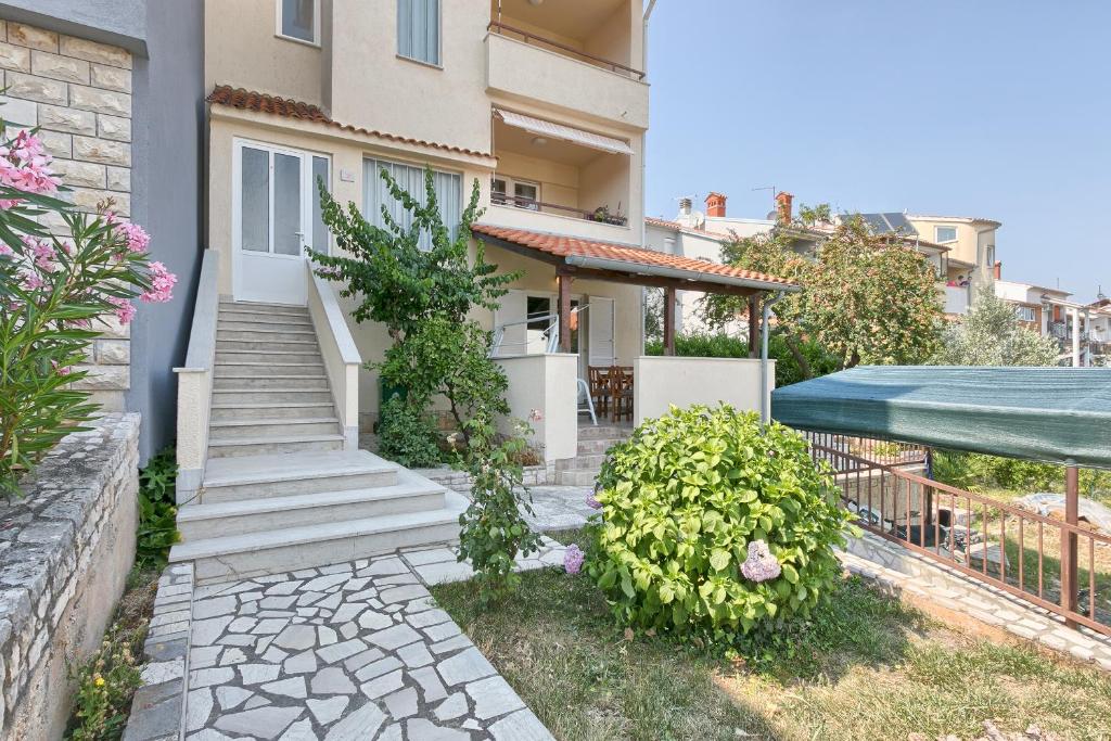 a house with a staircase in a yard at Apartments Veruda Porat in Pula