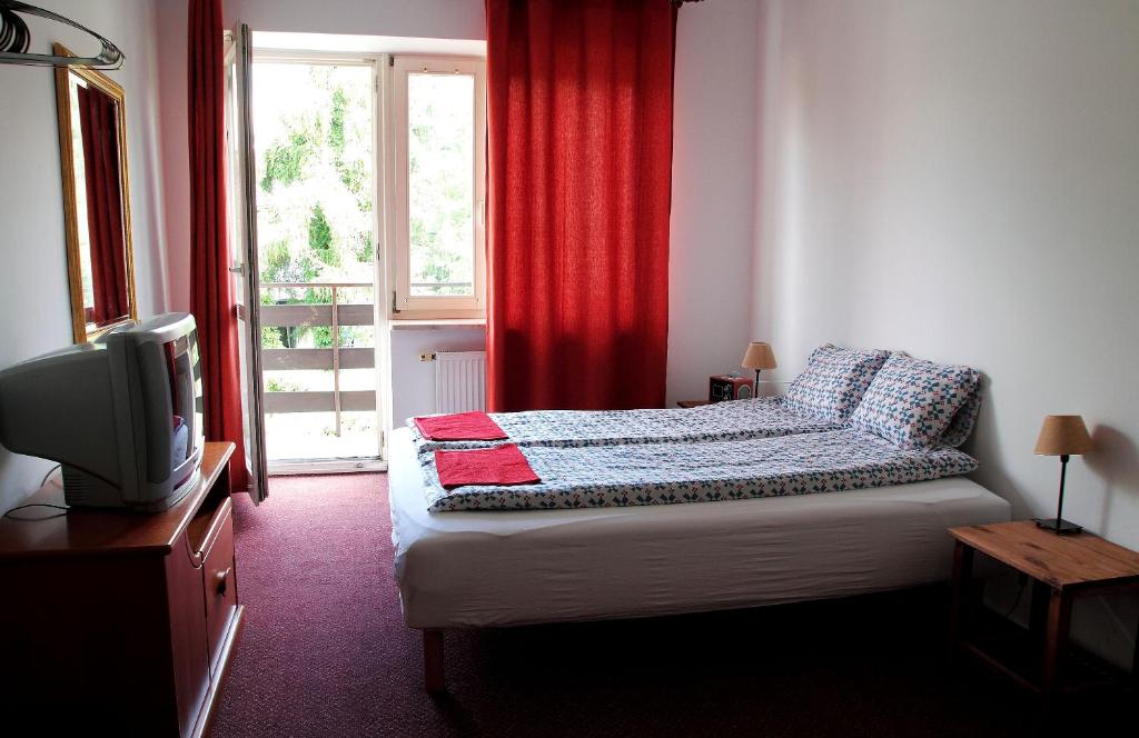 Schlafzimmer mit einem Bett, einem TV und einem Fenster in der Unterkunft Abracadabra in Warschau