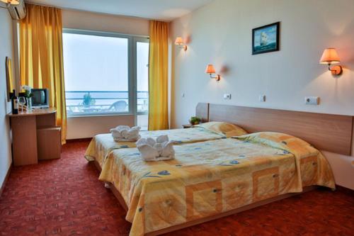 a hotel room with a bed and a large window at Vezhen Hotel - Free Parking in Golden Sands