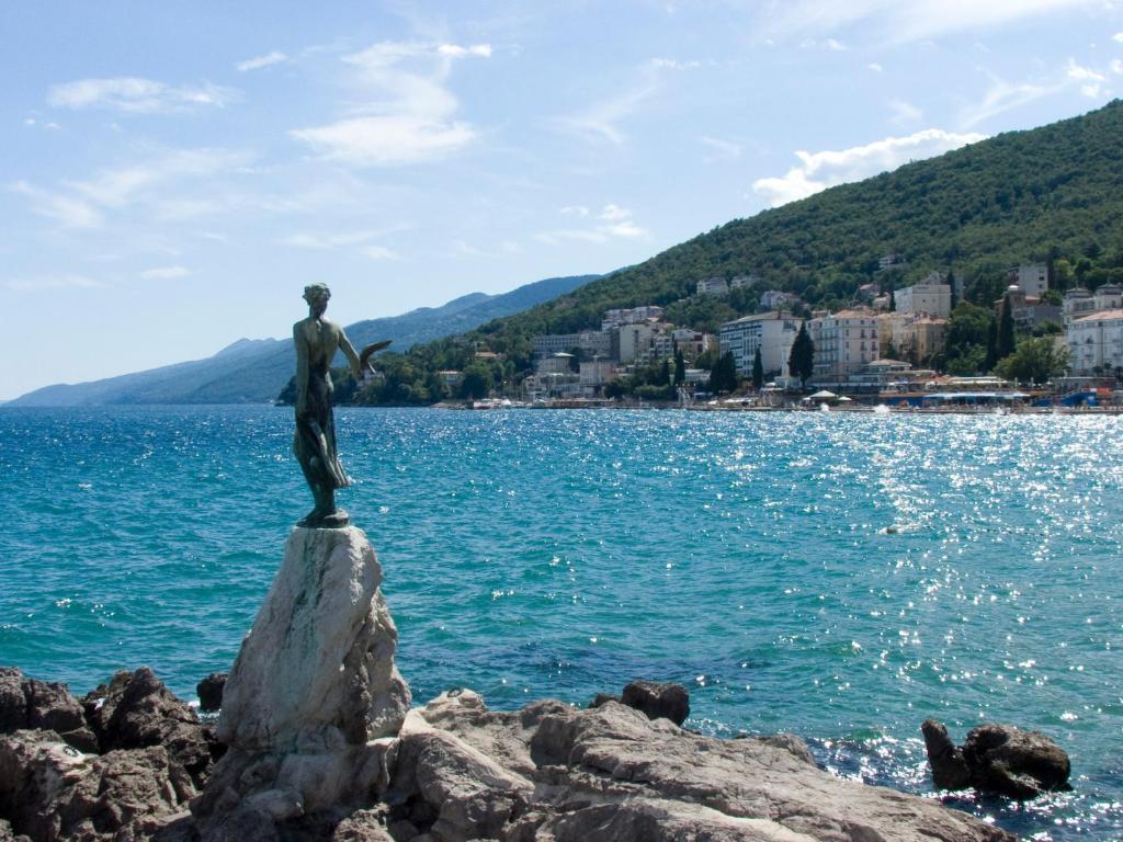 a statue on the shore of a body of water at Apartments Darinka in Opatija