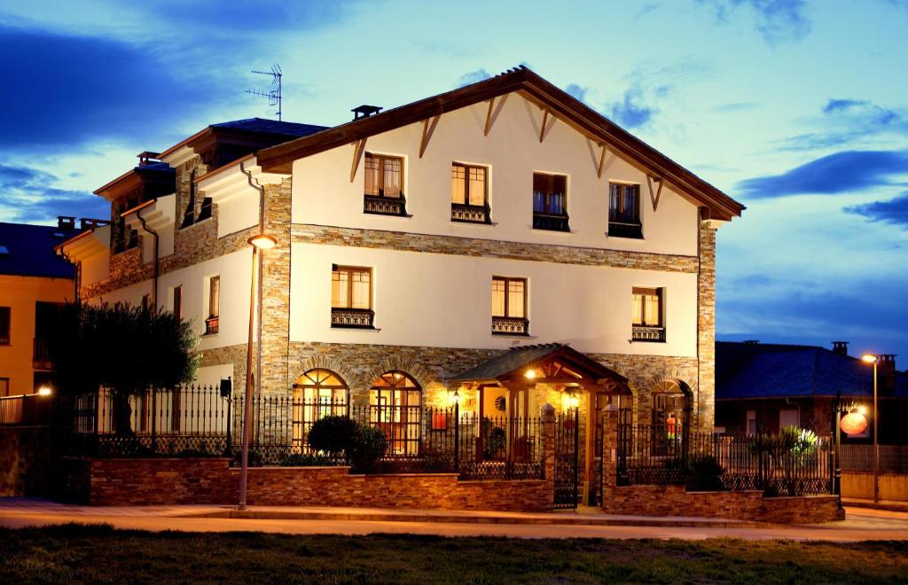 a large white house with a fence in front of it at As Tapias Apartamentos in Tapia de Casariego