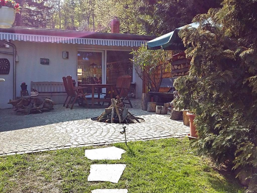 un patio trasero con una hoguera frente a una casa en Holiday home in Blankenburg with E station, en Blankenburg