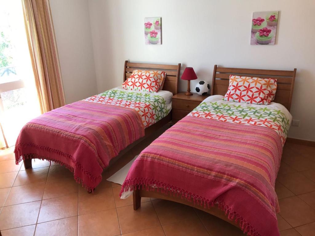 two beds sitting next to each other in a room at Tavira Garden- 2 bedrooms-2pools-2 balconies in Tavira