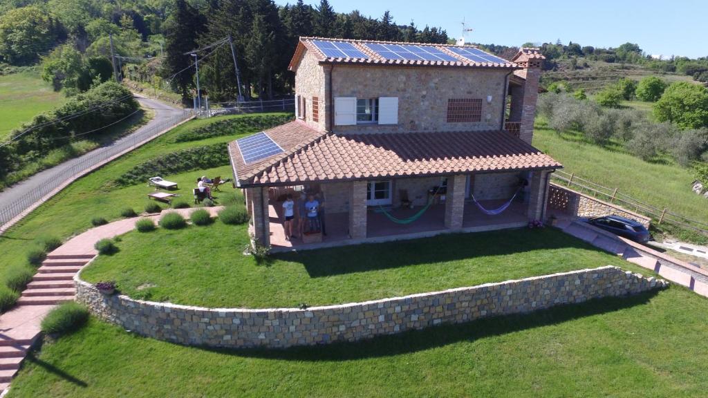 a house on top of a green field with a house at Dimora Degli Angeli in Chianni