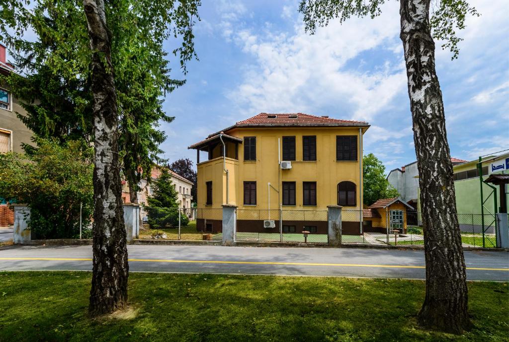 a yellow building on the side of a street at Vila Regina rooms in Karlovac