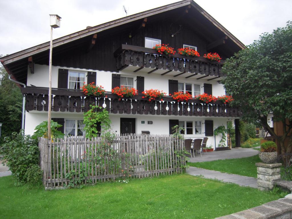 a house with flowers on the balconies and a fence at Gästehaus Dornach in Oberstdorf