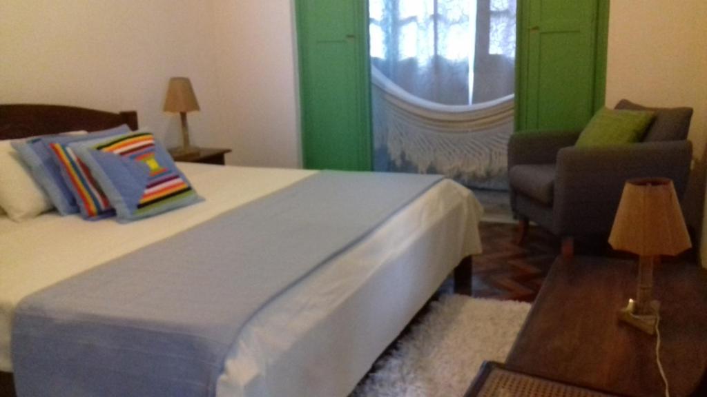 1 dormitorio con 1 cama, 1 silla y 1 ventana en Pousada Baluarte, en Salvador
