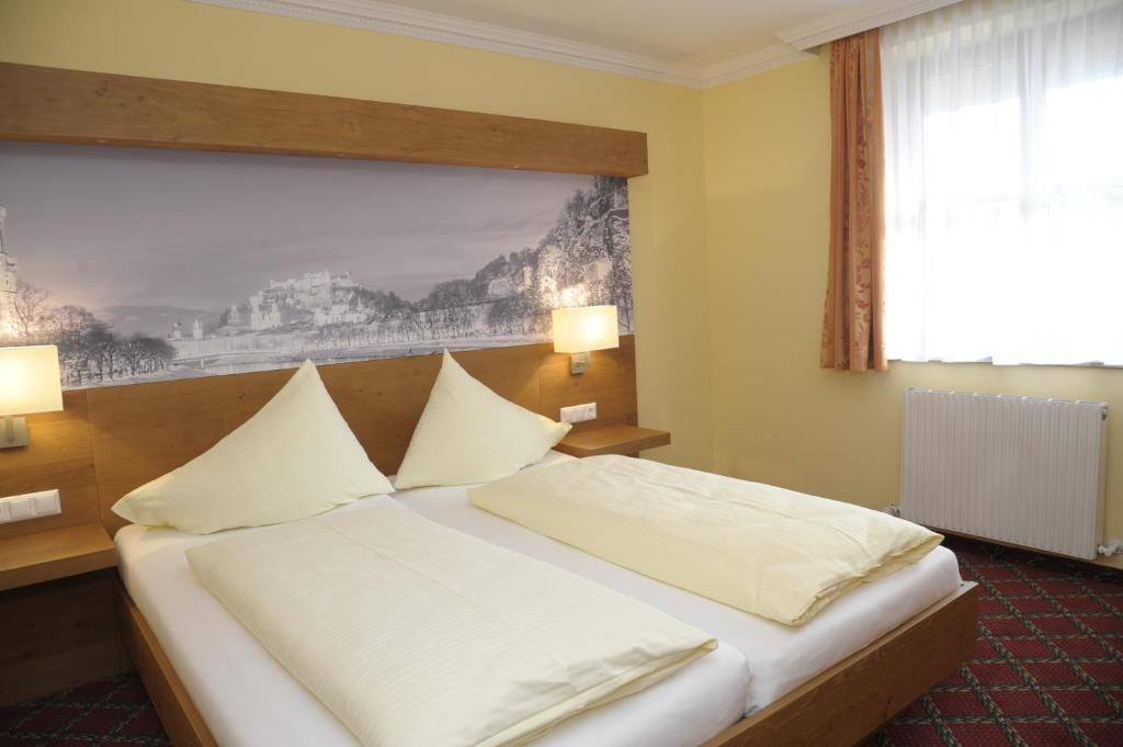 a hotel room with a bed with white pillows at Hotel Gasthof Kamml in Wals