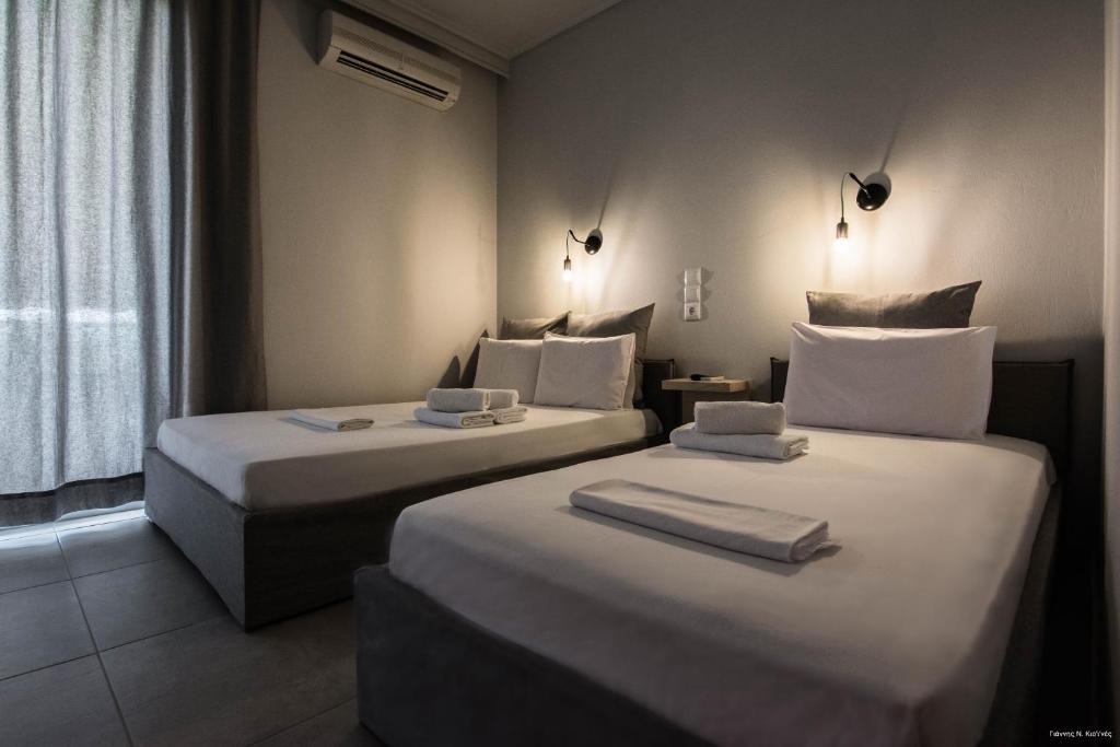 2 łóżka w pokoju hotelowym z ręcznikami w obiekcie Kochili Apartments w mieście Neos Pirgos