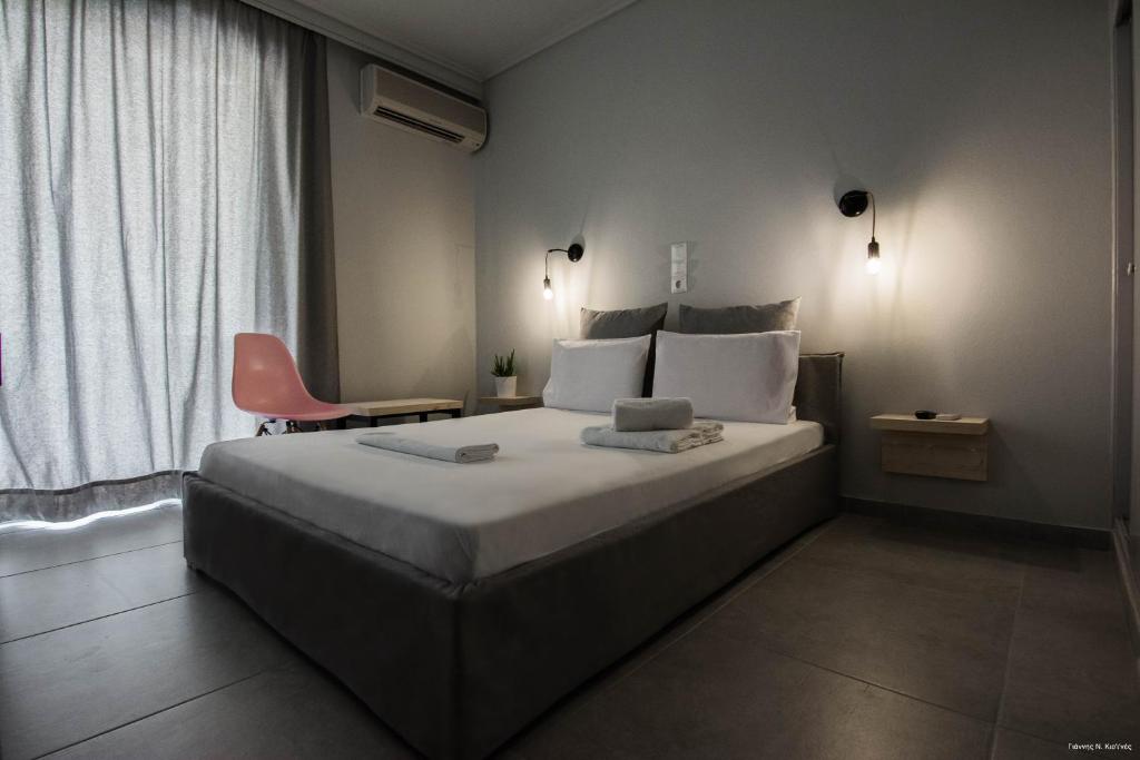 sypialnia z dużym łóżkiem i krzesłem w obiekcie Kochili Apartments w mieście Neos Pirgos