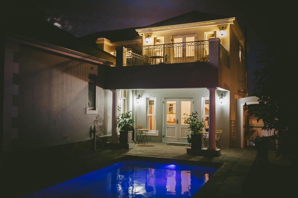 a house with a swimming pool at night at The Victorian Goose in Cape Town