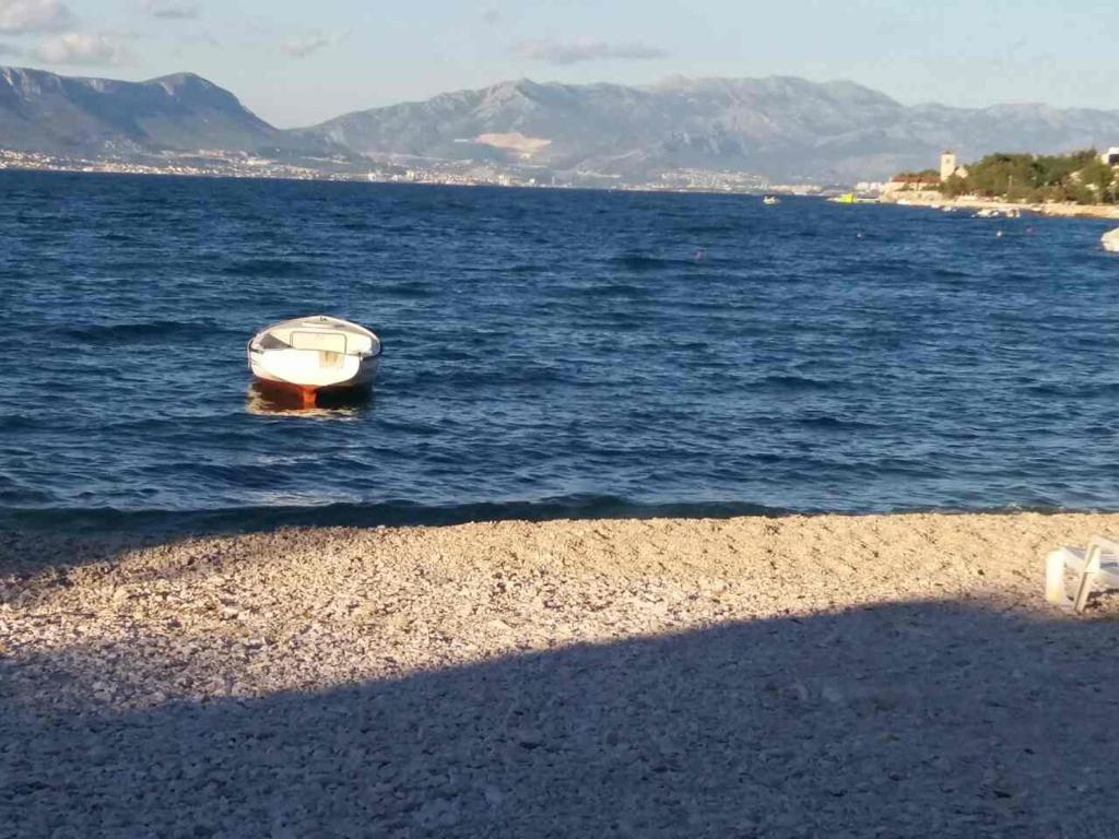 un barco en el agua junto a una playa en Apartments Paola en Trogir
