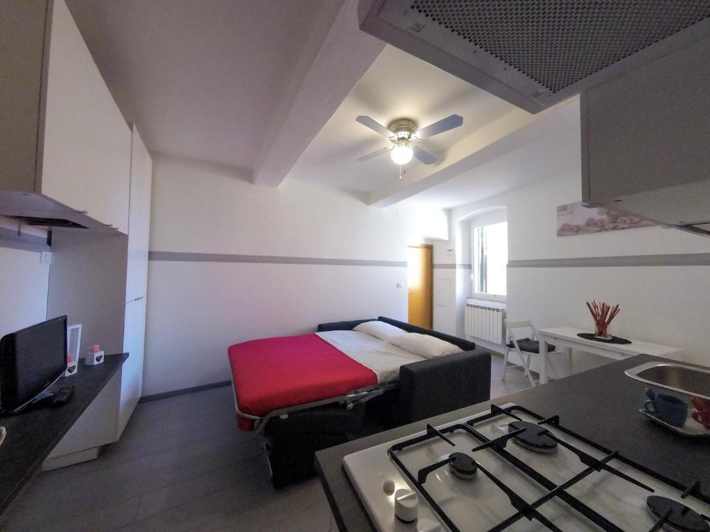 a room with a bed and a kitchen with a stove at Mi Va in Lerici