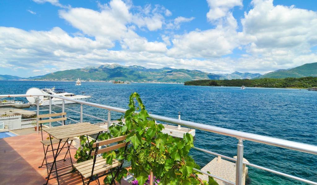 a boat on the water with mountains in the background at Apartments Novo Mulo in Tivat
