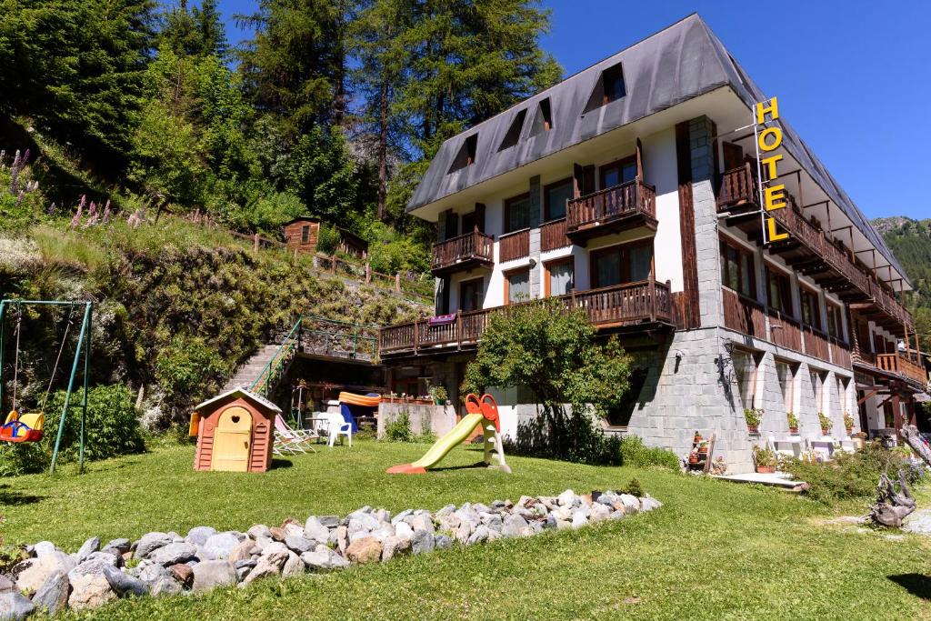 una persona jugando en un tobogán delante de un edificio en Hotel Genzianella en Champoluc