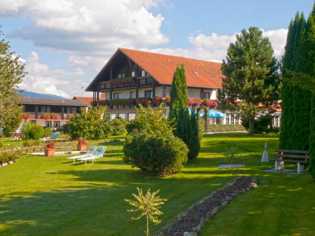 un gran edificio con un patio con un banco en Landhotel Rappenhof, en Arnbruck