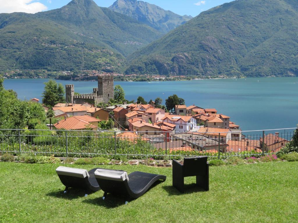 zwei Sitze im Gras mit Blick auf eine Stadt und Berge in der Unterkunft Ficano's Dream in San Siro