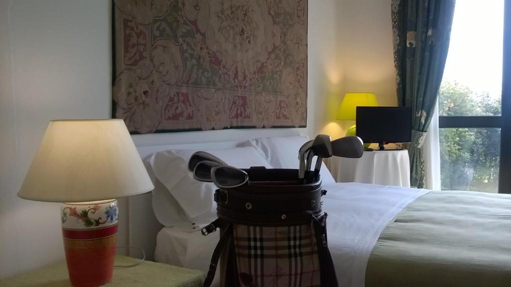 a room with a bed with a lamp and microphones at Green house Marco Simone Golf Club in Marco Simone