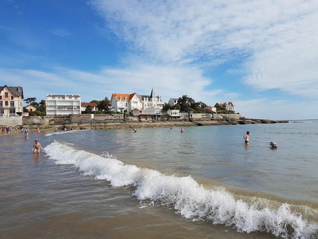 a group of people in the water at the beach at residence parc de pontaillac in Vaux-sur-Mer