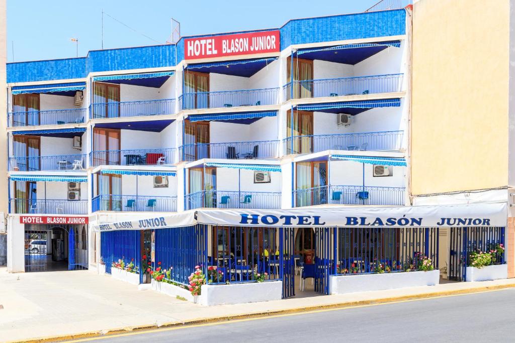 a hotel with blue balconies on a street at Hotel Blason Junior in Peniscola