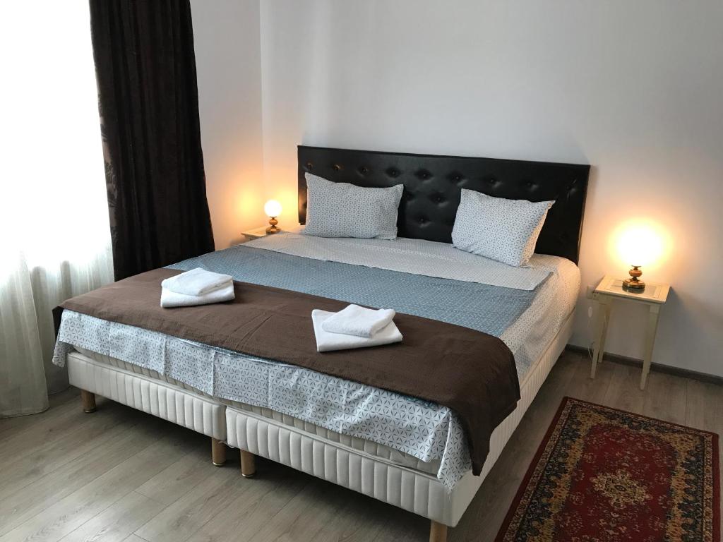 a bedroom with a large bed with two towels on it at Cochet Accommodation in Piatra Neamţ