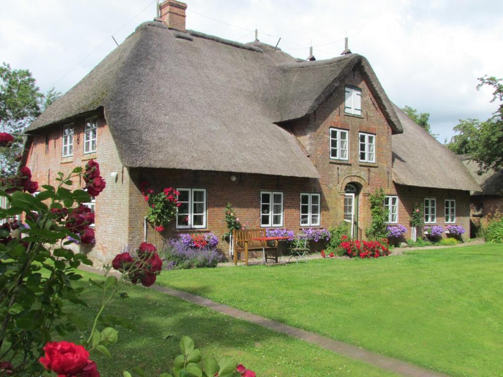 una gran casa de ladrillo con techo de paja en Historischer Davidshof - Mit dem Rad die Nordseehalbinsel erkunden, en Oldenswort