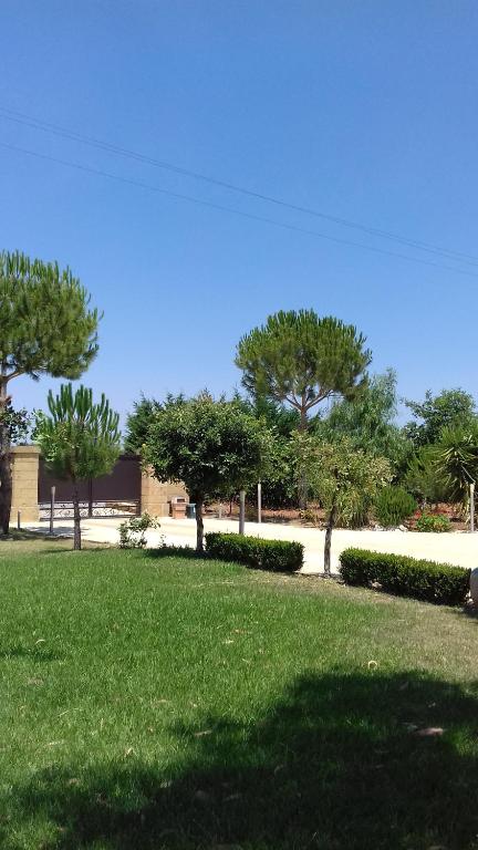 um parque com relva verde e árvores ao fundo em La Macchia em Botrugno