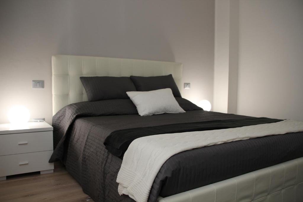 a bedroom with a large bed and a night stand at CallaslivinG in Verona