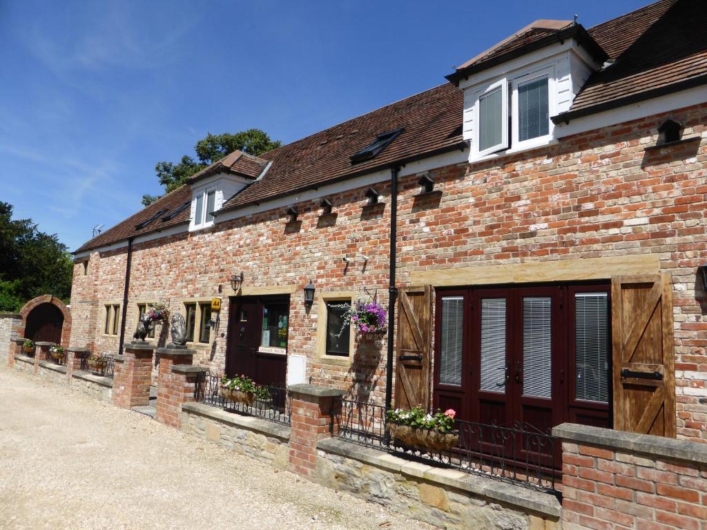 an old brick building with doors and windows at Liongate House in Ilchester