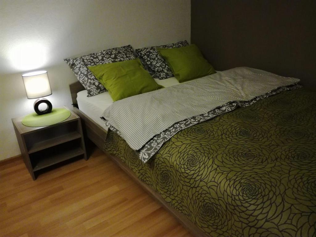 エカテリンブルクにあるApartment Green Islandのベッドルーム1室(緑の枕とテーブル付)