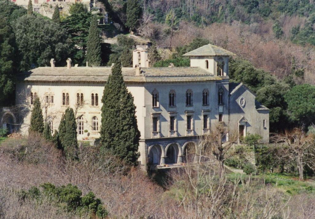 uma casa grande numa colina com uma torre em CHÂTEAU CAGNINACCI B&B em San-Martino-di-Lota