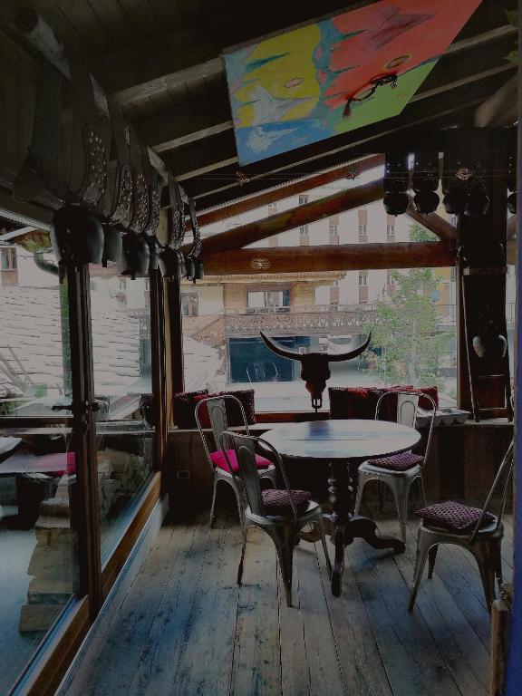 a table and chairs in a room with a window at Hotel Punta Maquignaz in Breuil-Cervinia