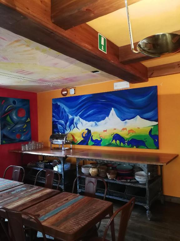 a dining room with a painting on the wall at Hotel Punta Maquignaz in Breuil-Cervinia