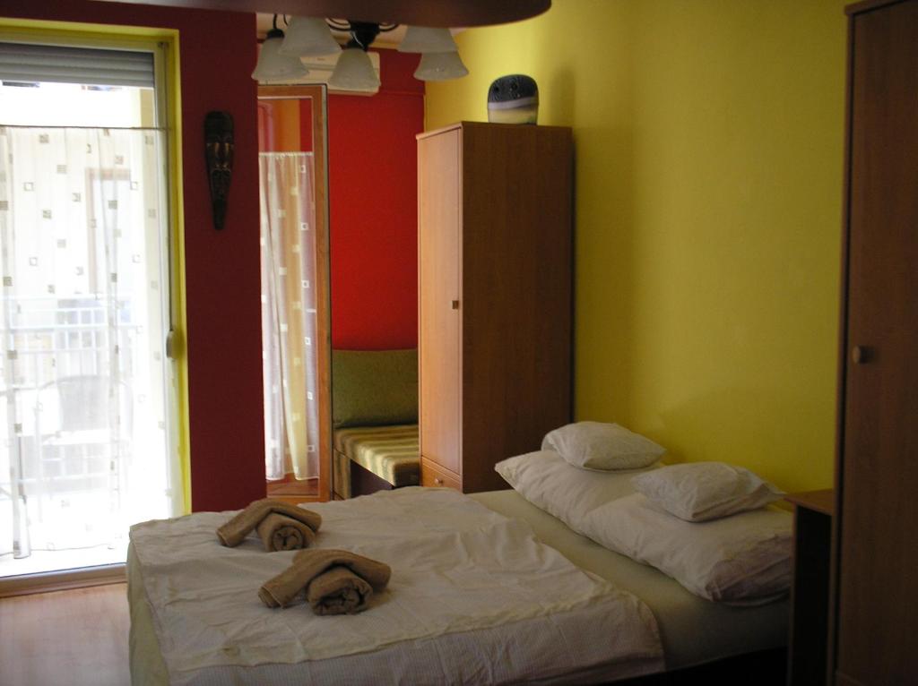 - 2 lits dans une chambre avec des serviettes dans l'établissement Mediterrán Szállás, à Gyula